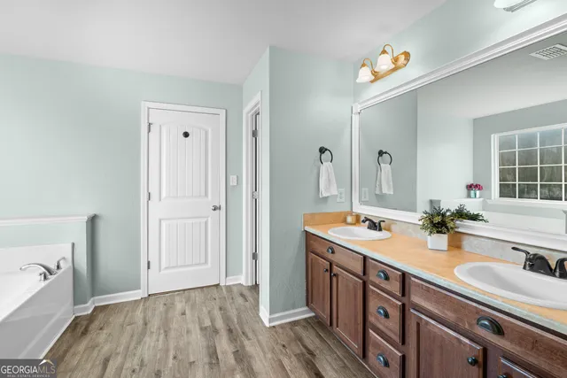 a bathroom with a granite countertop sink and a mirror white walls