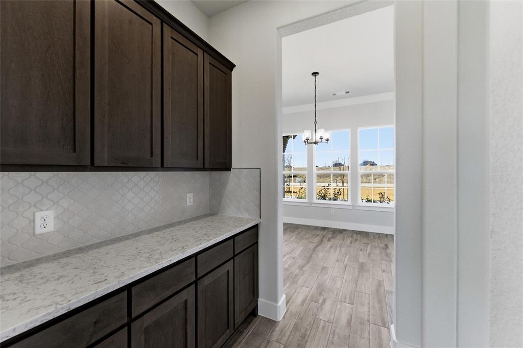 805 Vly Rdg Road Van Alstyne, TX 75495 - Photo 12 of 40 a kitchen with a wooden floor and a large window