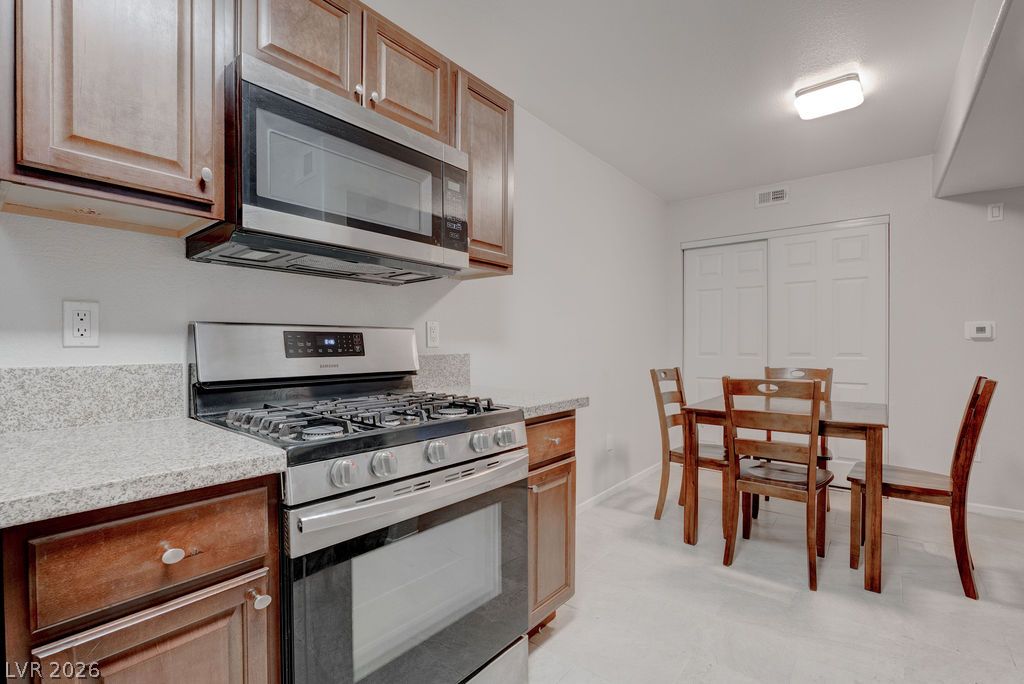 7885 West Flamingo Road, Unit 1016 Las Vegas, NV 89147 - Photo 12 of 24 Prepare meals in a kitchen featuring sleek stainless steel appliances and durable granite countertops.