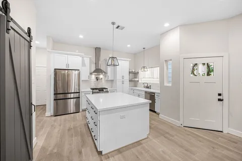 a kitchen with stainless steel appliances a refrigerator sink and microwave