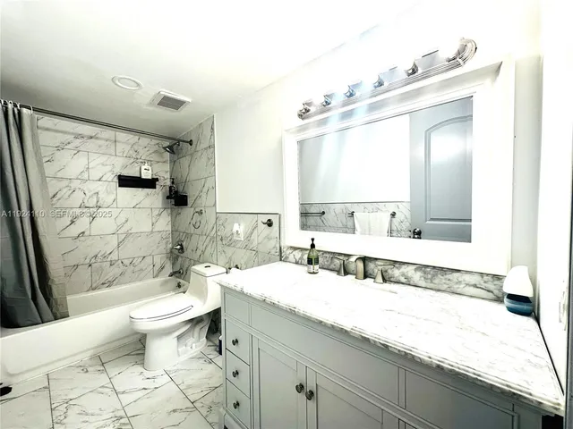 a bathroom with a double vanity sink mirror and toilet