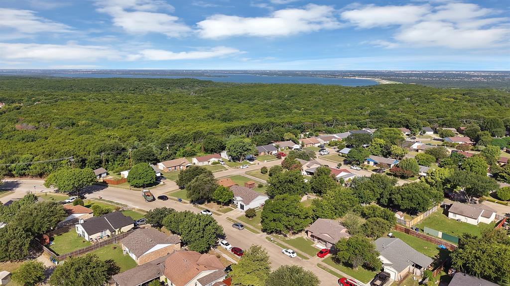 9519 County View Road Dallas, TX 75249 - Photo 26 of 31 Aerial perspective showcasing a residential neighborhood bordering a substantial expanse of green space and a distant body of water