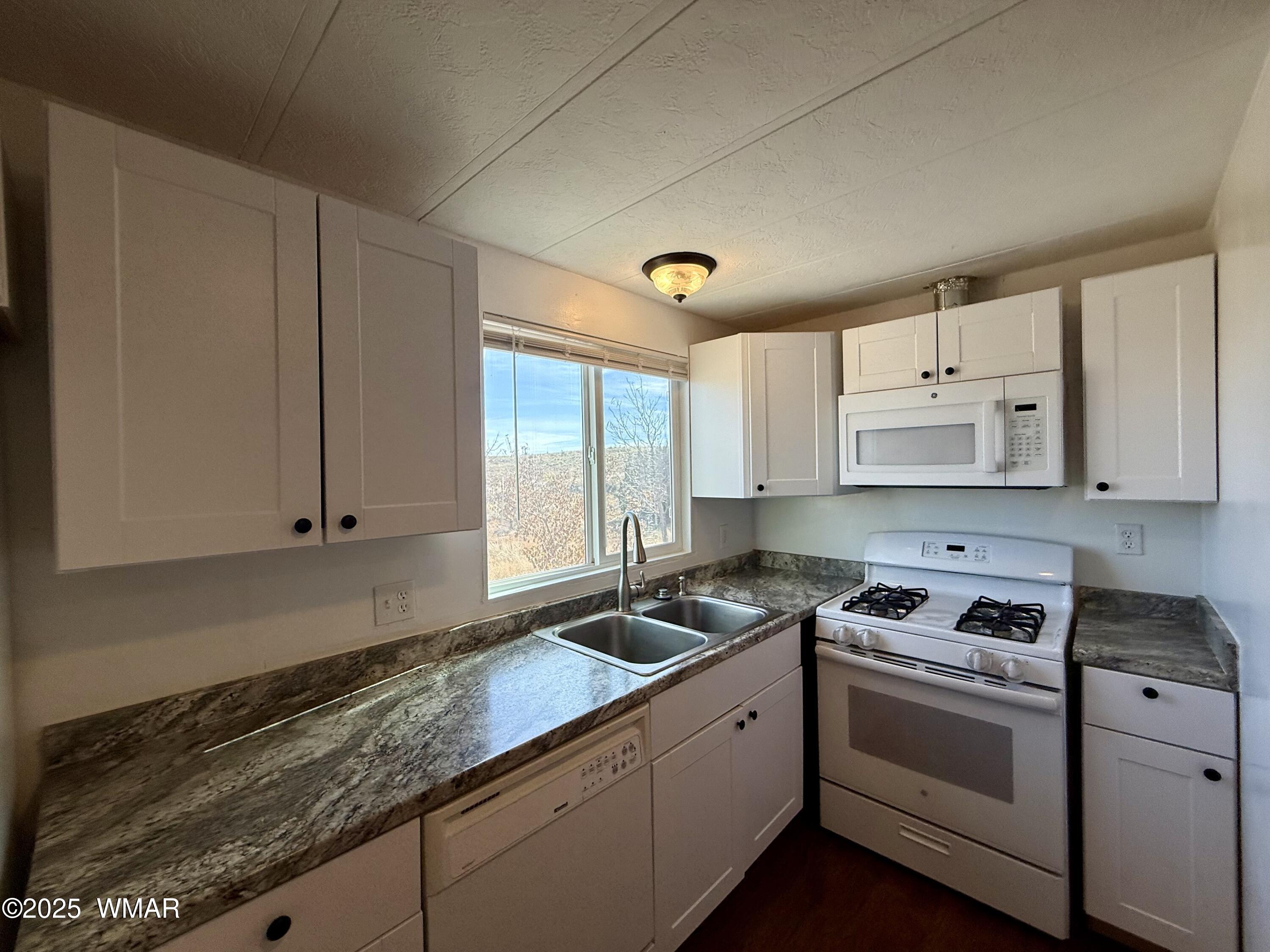 3908 South Freeman Holw Road Snowflake, AZ 85937 - Photo 7 of 31 a kitchen with granite countertop a sink a stove and cabinets