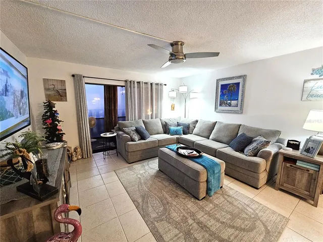 a living room with furniture a ceiling fan and a window