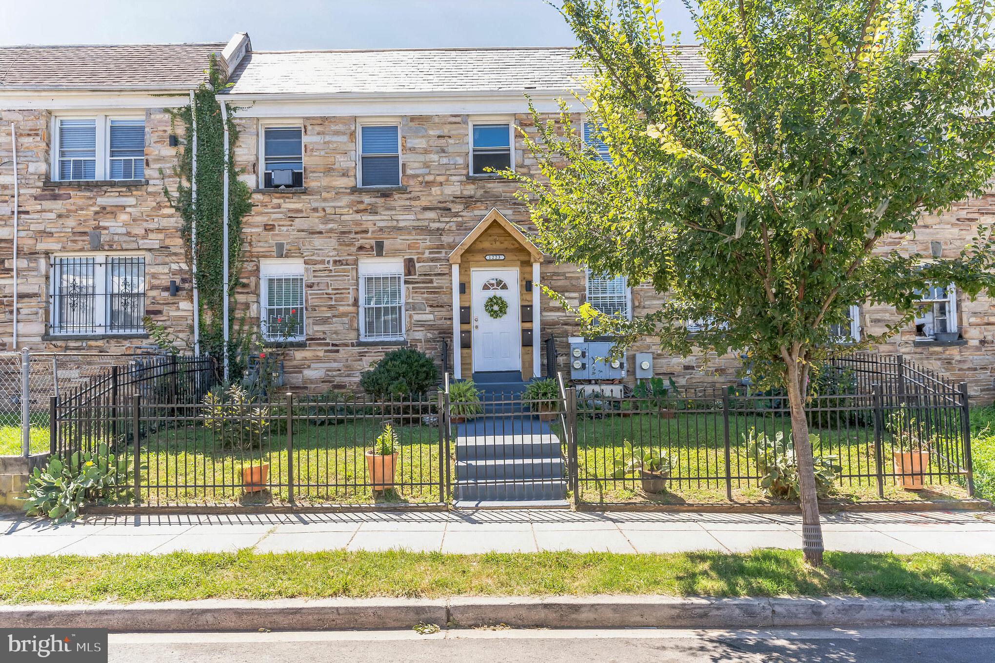 1223 Simms Place Northeast, Unit 1 Washington, DC 20002 - Photo 1 of 48 a front view of a house with a garden and plants
