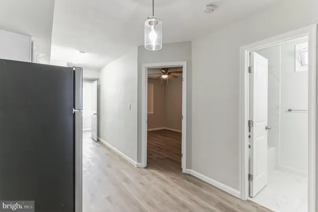 a view of a hallway with wooden floor and closet area