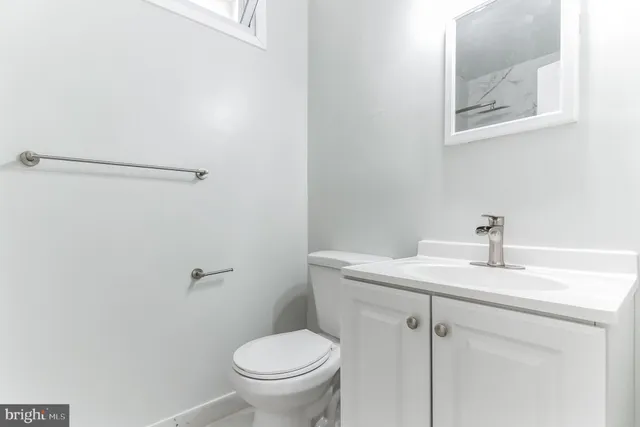 a bathroom with a sink mirror vanity and toilet