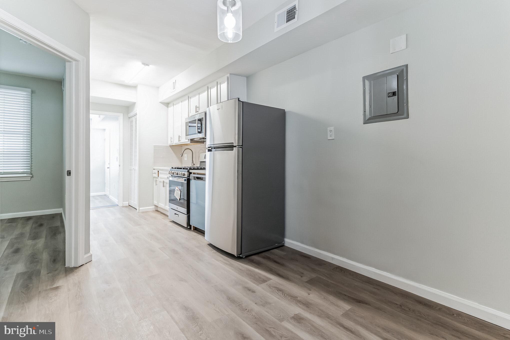 1223 Simms Place Northeast, Unit 1 Washington, DC 20002 - Photo 32 of 48 a view of a kitchen with refrigerator and wooden floor