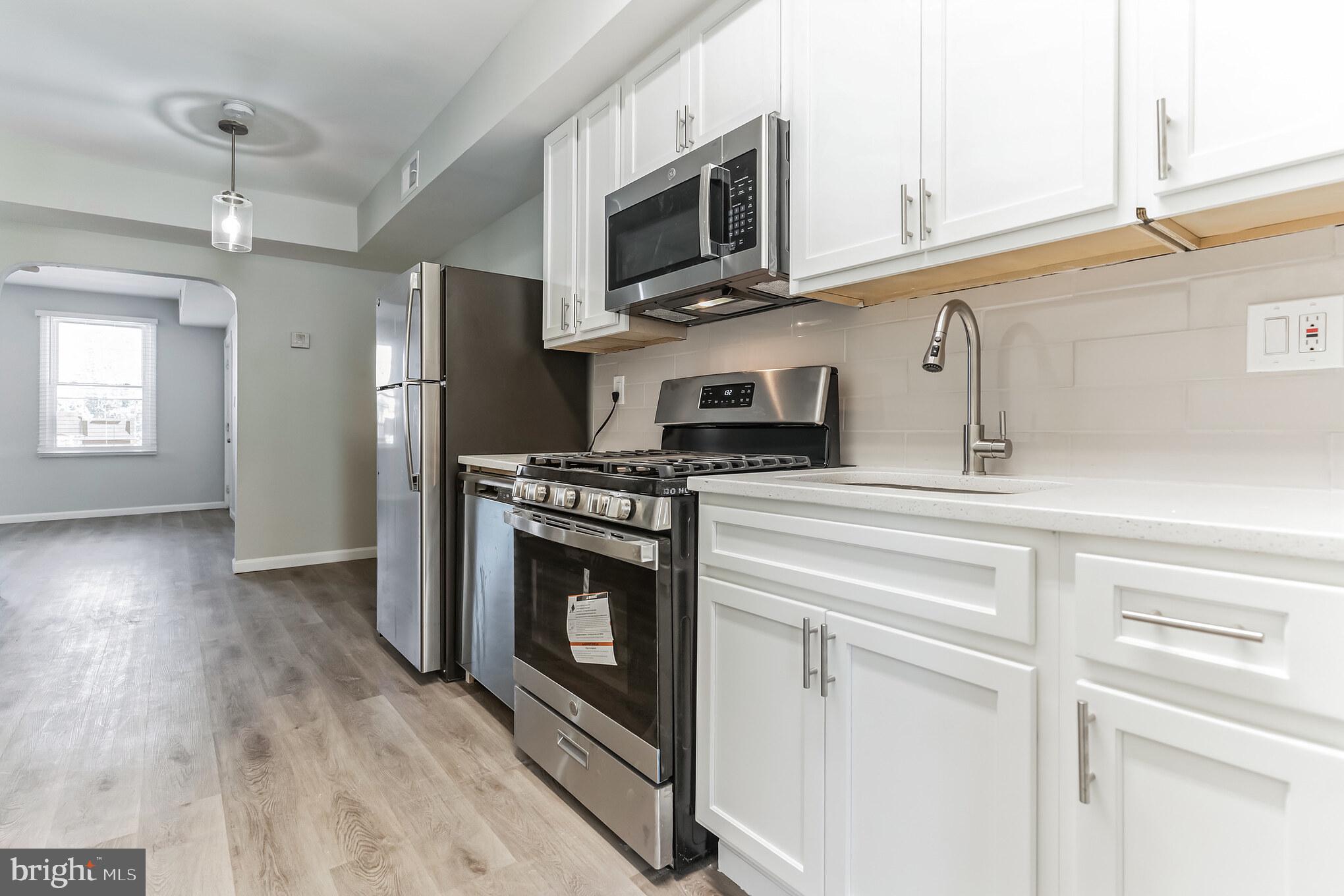 1223 Simms Place Northeast, Unit 1 Washington, DC 20002 - Photo 37 of 48 a kitchen with stainless steel appliances a stove a microwave and cabinets