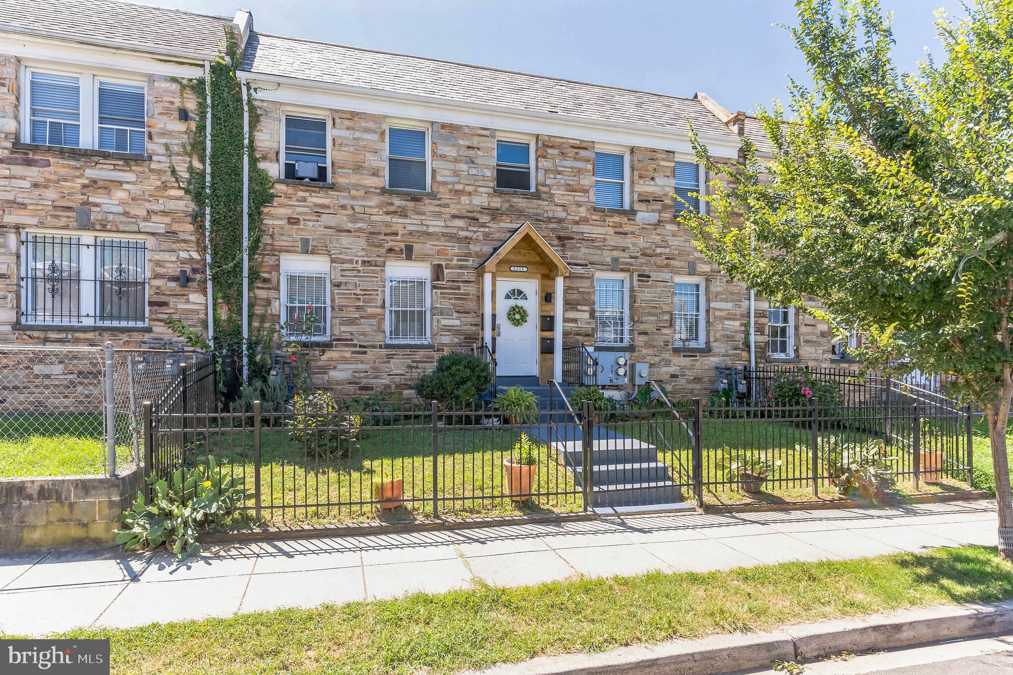1223 Simms Place Northeast, Unit 1 Washington, DC 20002 - Photo 4 of 48 a front view of a house with a yard table and chairs