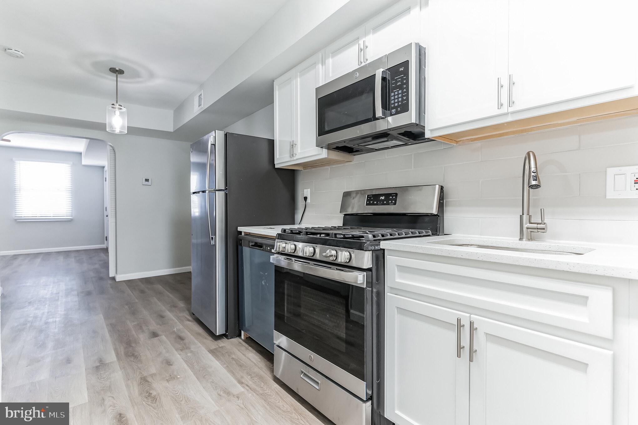 1223 Simms Place Northeast, Unit 1 Washington, DC 20002 - Photo 6 of 48 a kitchen with stainless steel appliances granite countertop a stove microwave and refrigerator