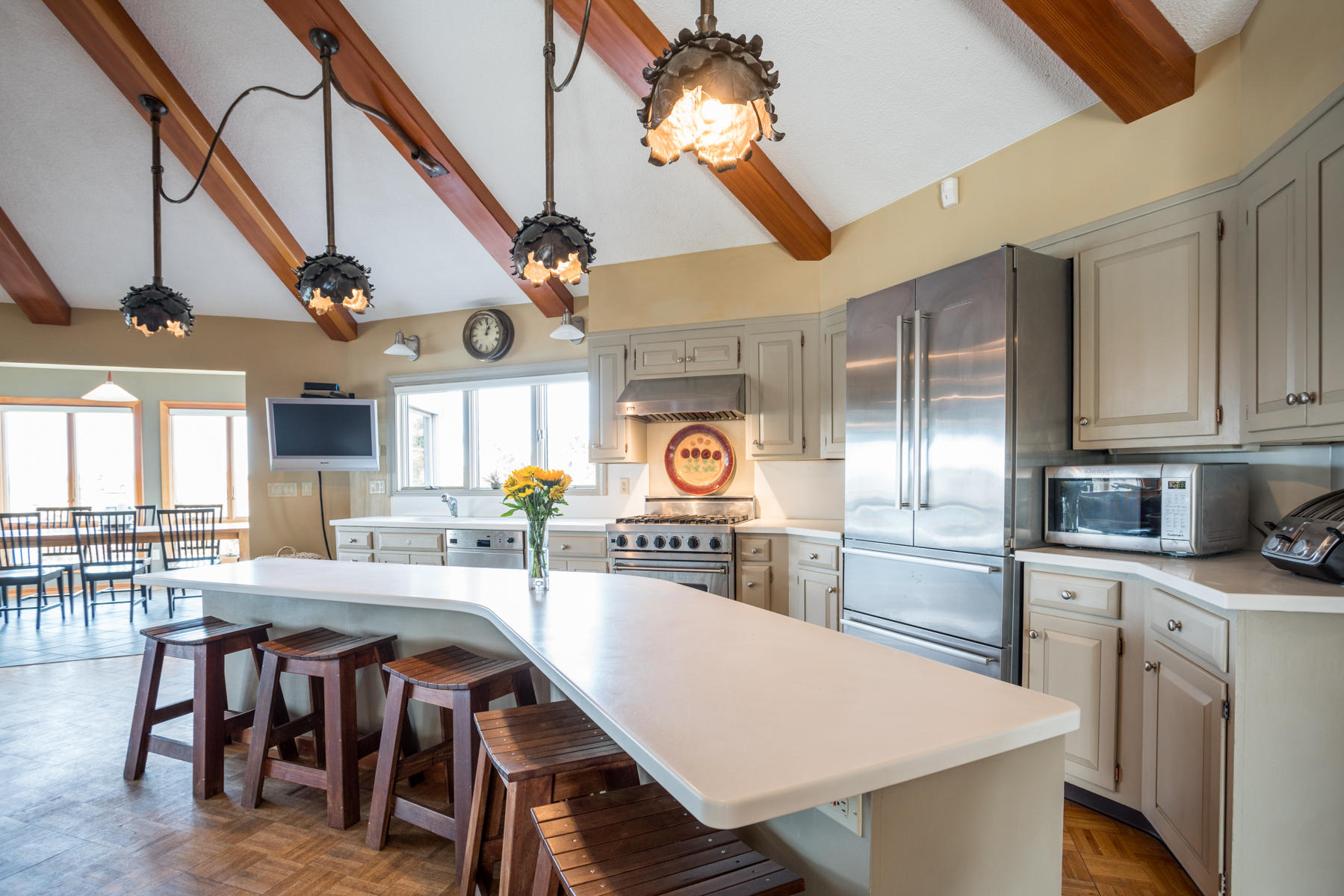 100 Freeman Lane Orleans, MA 02653 - Photo 17 of 34 a kitchen with stainless steel appliances granite countertop a stove a refrigerator a dining table and chairs with wooden floor