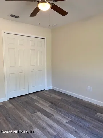 a view of a yard with an tree and front house with wooden fence