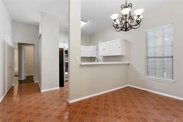 a view of a kitchen with an empty space and chandelier