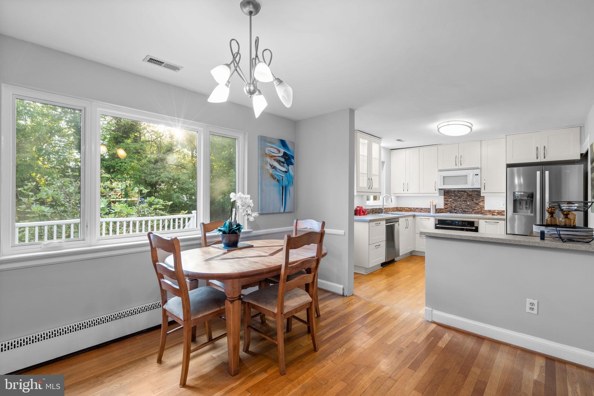 2306 Barbour Road Falls Church, VA 22043 - Photo 11 of 37 a view of a dining room with furniture large windows a chandelier and wooden floor
