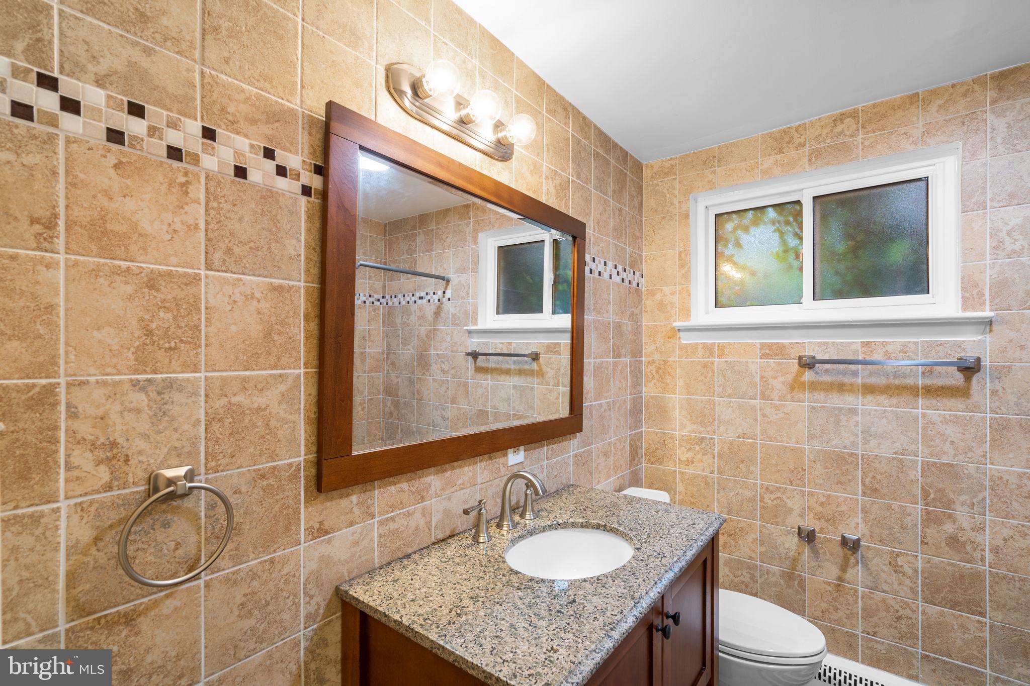 2306 Barbour Road Falls Church, VA 22043 - Photo 27 of 37 a bathroom with a granite countertop sink a toilet and shower