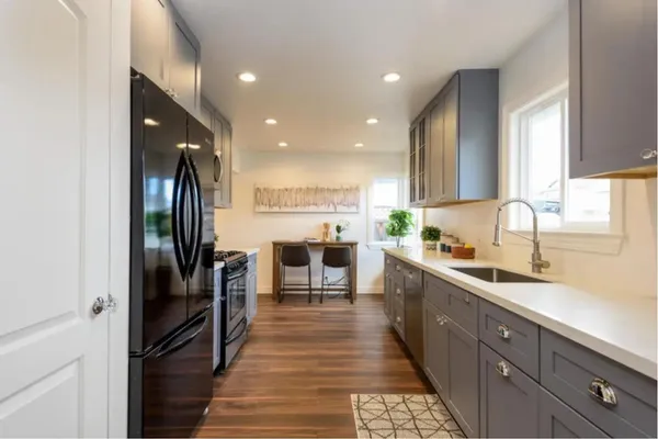a open kitchen with stainless steel appliances granite countertop a refrigerator and a sink