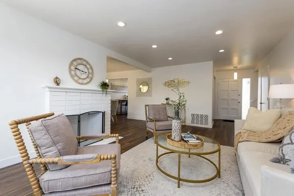 a living room with furniture a fireplace and wall paintings