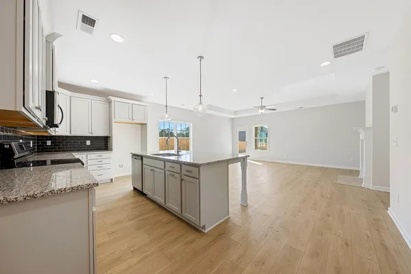 a kitchen with stainless steel appliances granite countertop a sink a stove top oven a counter space and cabinets