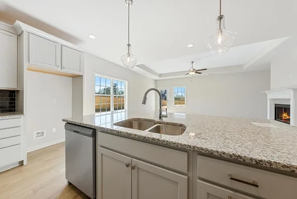 a kitchen with granite countertop a sink and white cabinets