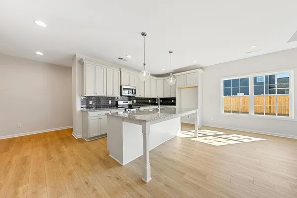 a large kitchen with granite countertop a stove a sink and a refrigerator