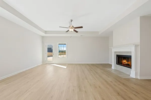 an empty room with a fireplace and wooden floor