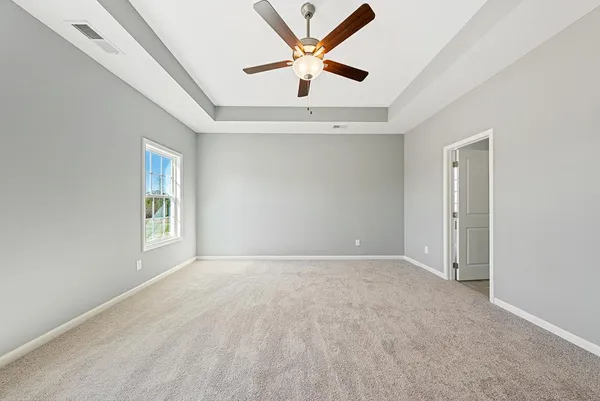 an empty room with window and ceiling fan