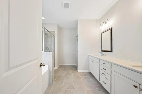 a spacious bathroom with a double vanity sink a mirror and a bathtub