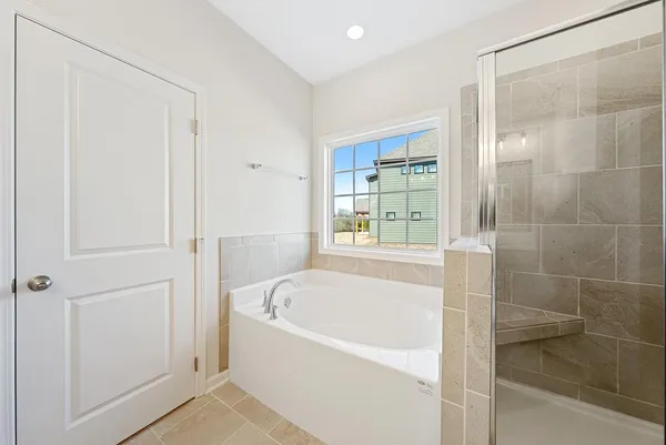 a white bath tub sitting next to a shower