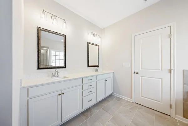 a bathroom with a double vanity sink and a mirror