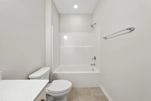 a white toilet sitting next to a bath tub