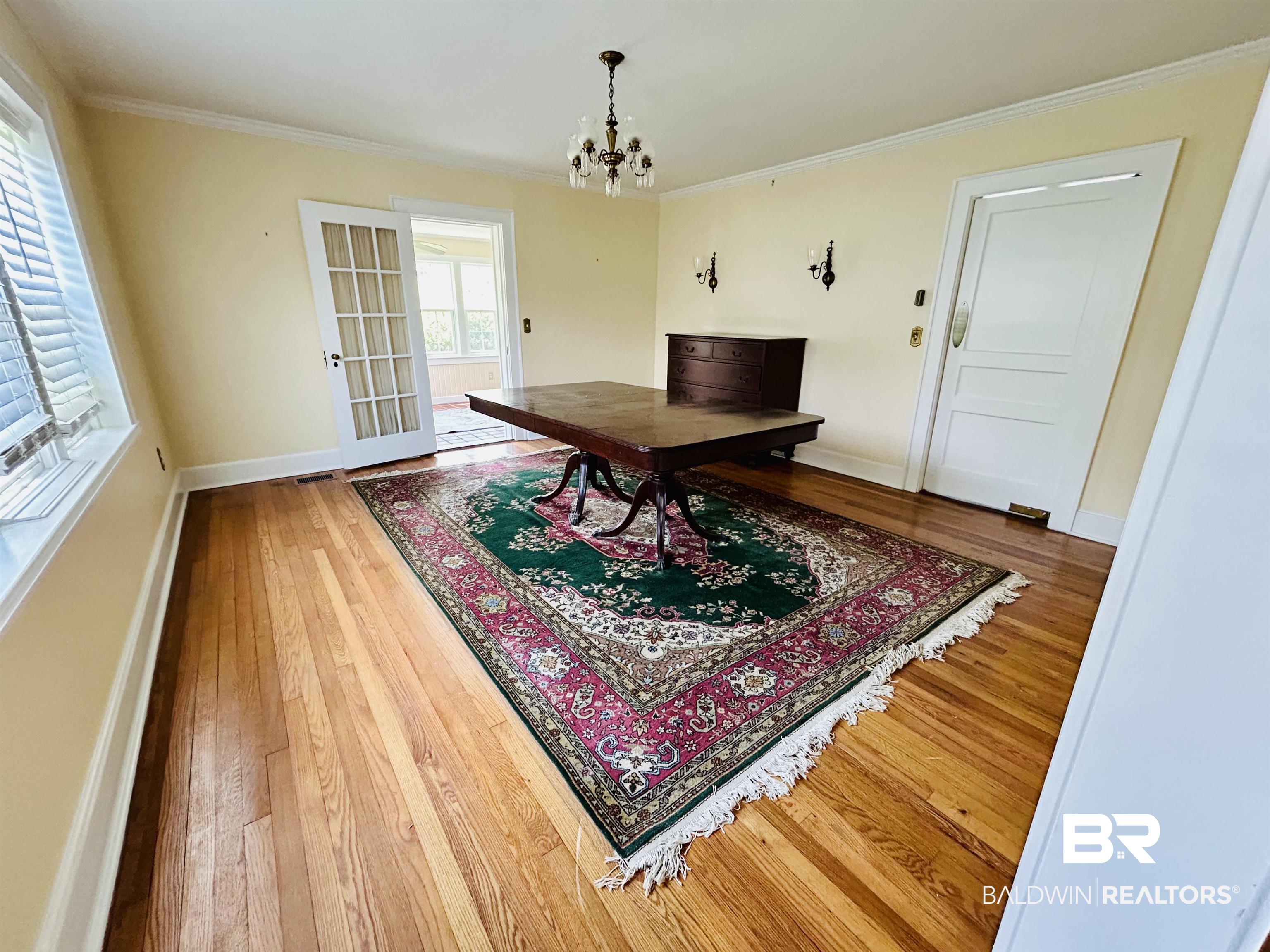 1405 Escambia Avenue Brewton, AL 36426 - Photo 5 of 16 Dining room featuring crown molding, wood finished floors, and a chandelier