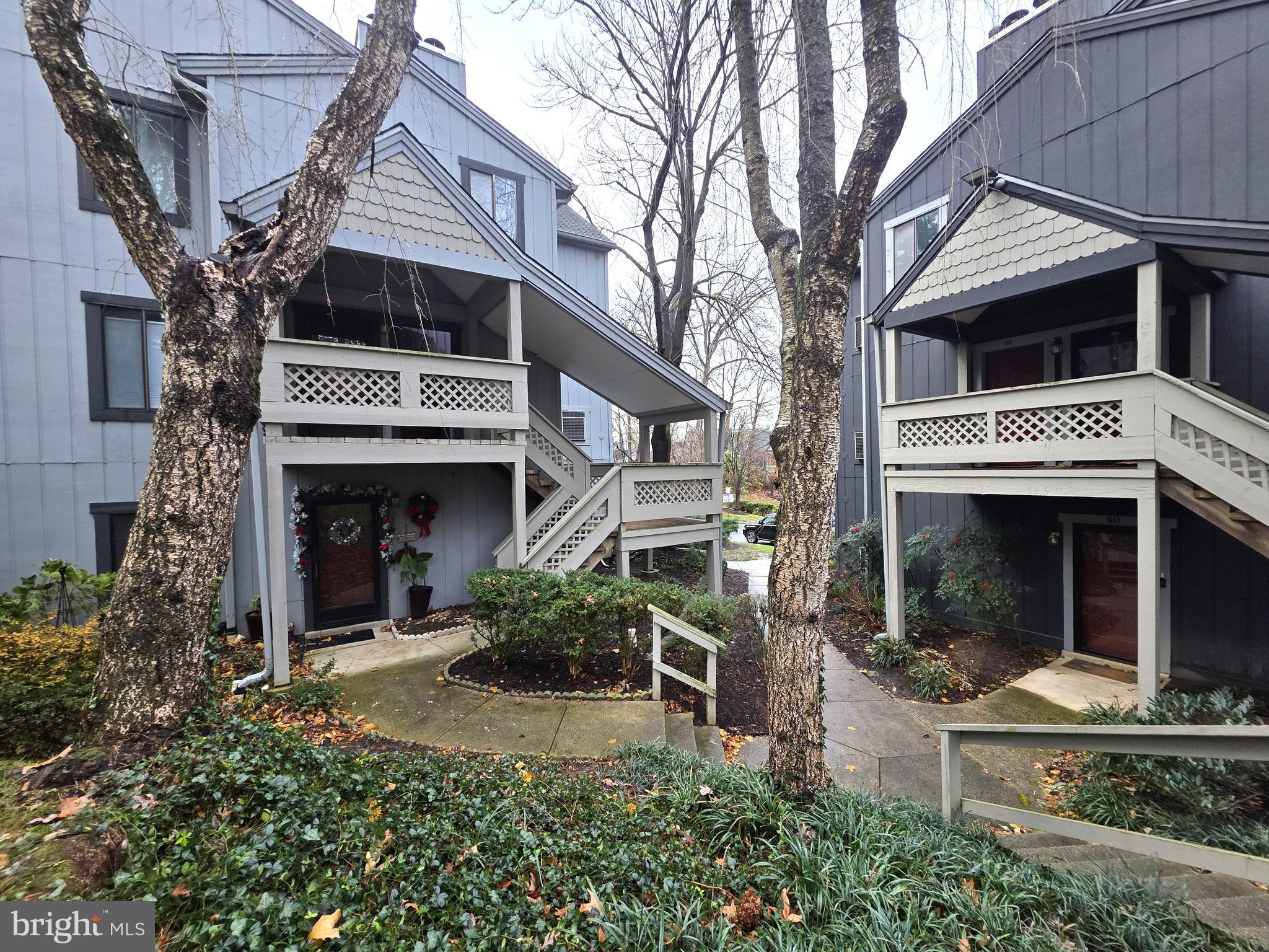 a view of a white house with large windows and a small yard
