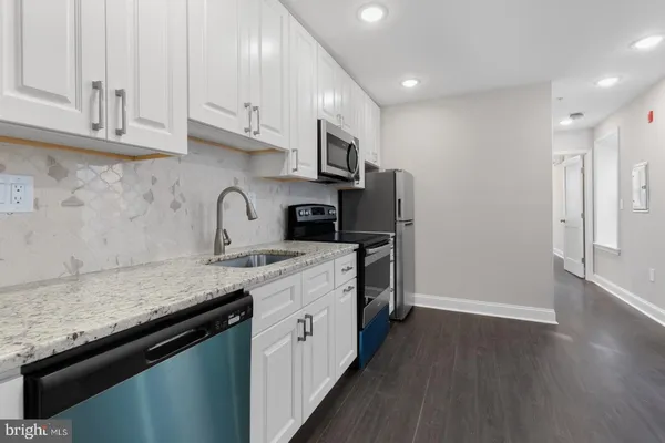 a kitchen with stainless steel appliances granite countertop a stove a sink and a refrigerator