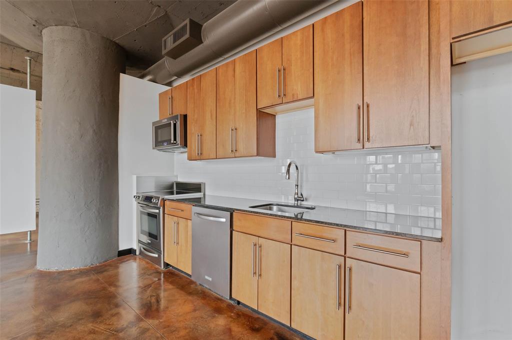 1122 Jackson Street, Unit 313 Dallas, TX 75202 - Photo 12 of 27 a kitchen with stainless steel appliances granite countertop a sink stove and cabinets