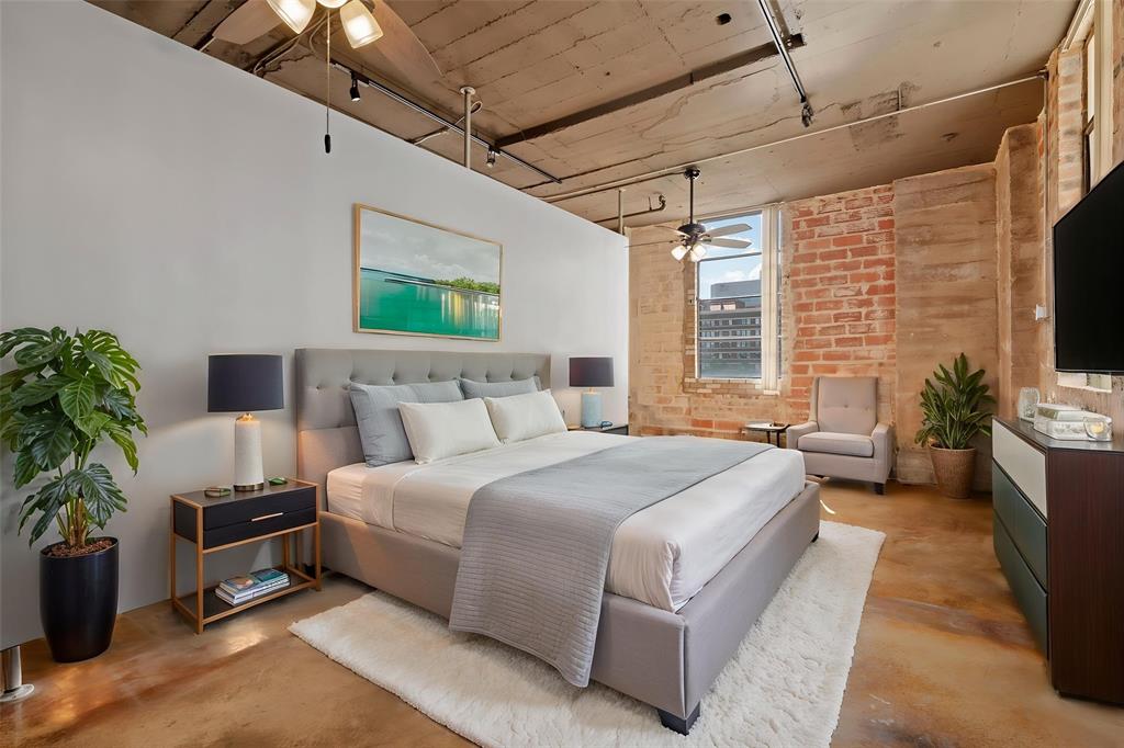 1122 Jackson Street, Unit 313 Dallas, TX 75202 - Photo 17 of 27 a bedroom with bed and a potted plant
