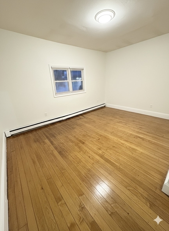 36 Sagamore Street, Unit 3 Lynn, MA 01902 - Photo 12 of 19 an empty room with wooden floor and windows