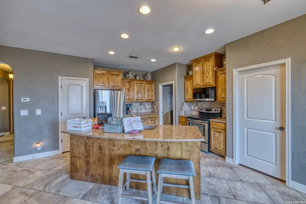 a kitchen with kitchen island granite countertop a stove and a sink