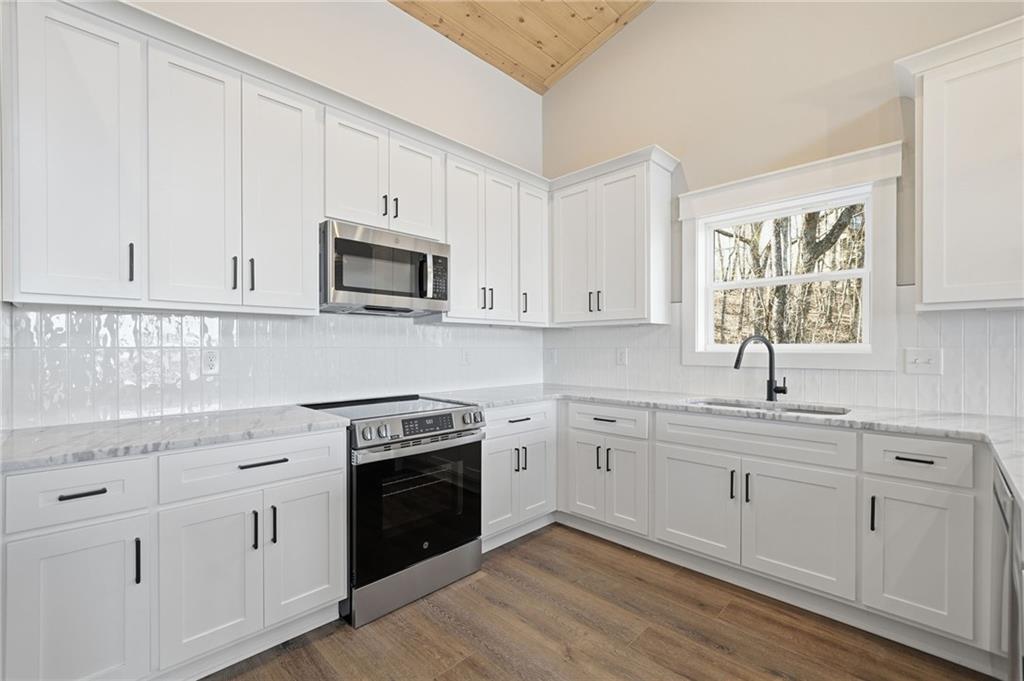1176 Jewel Court Northeast Ranger, GA 30734 - Photo 11 of 53 a kitchen with white cabinets and white appliances