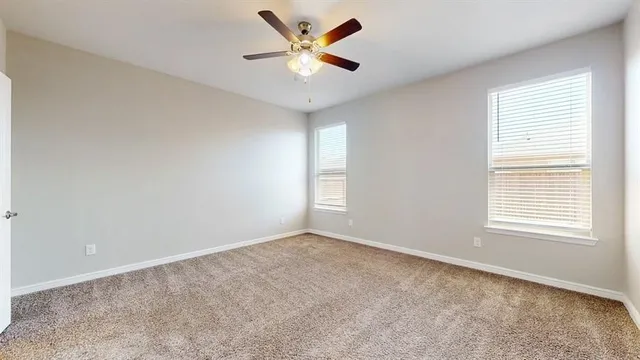 an empty room with a window and a fan