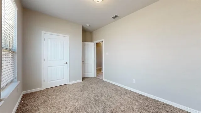 an empty room with windows and closet