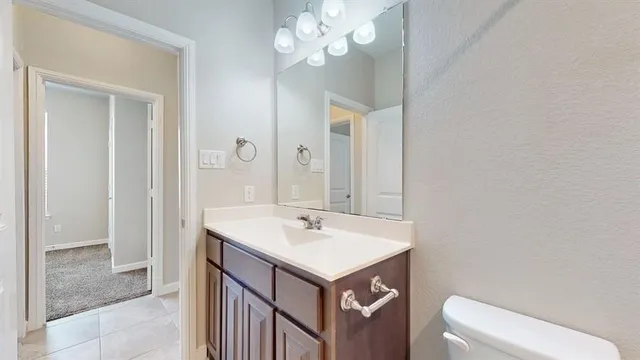 a bathroom with a sink a toilet and a mirror