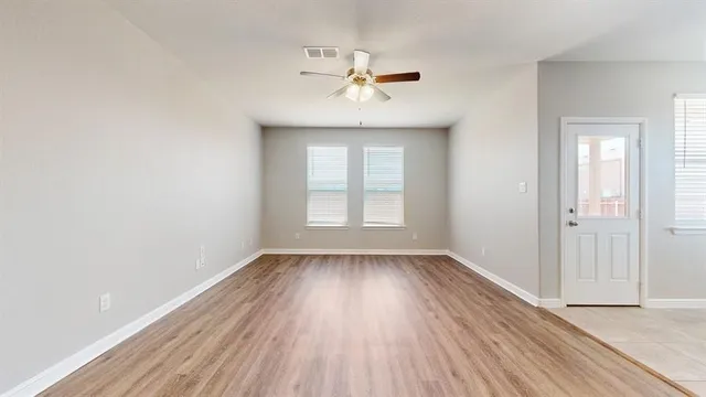 an empty room with a window and wooden floor