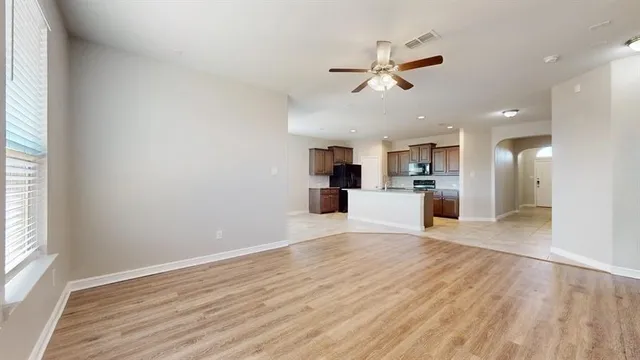 a view of a kitchen with wooden floor and a window