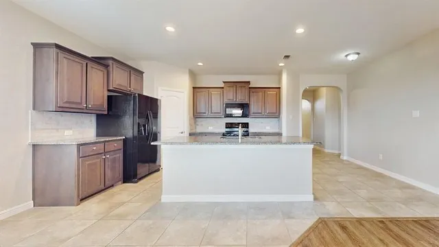 a view of kitchen with stainless steel appliances granite countertop a refrigerator sink and cabinets