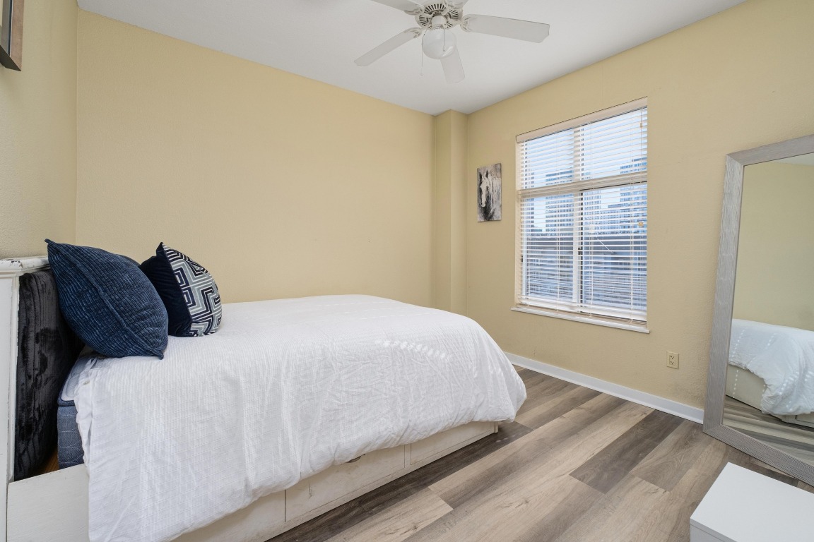 711 West 26th Street, Unit 706 Austin, TX 78705 - Photo 13 of 24 a bedroom with a bed and a chandelier