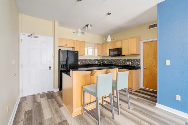 a kitchen with stainless steel appliances granite countertop a refrigerator a stove a sink dishwasher and a stove with wooden floor