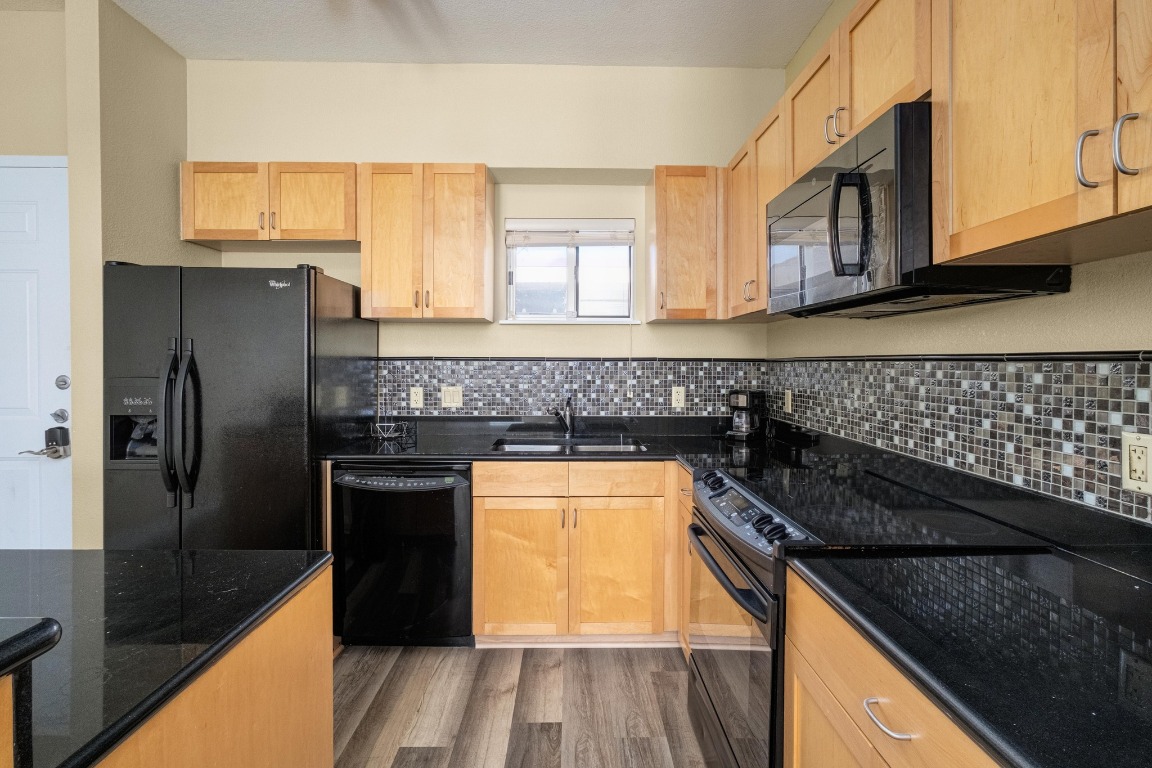 711 West 26th Street, Unit 706 Austin, TX 78705 - Photo 7 of 24 a kitchen with granite countertop stainless steel appliances a stove sink and refrigerator