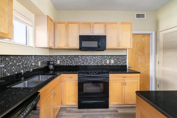 a kitchen with granite countertop a stove and a sink