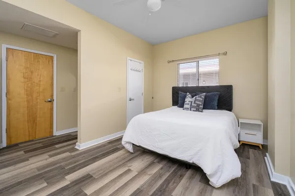 a bedroom with a bed and wooden floor
